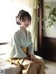 A woman in a kimono sitting on a bed.