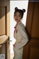 A woman standing in front of a wooden door.