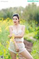 A woman in a white dress standing in a field of yellow flowers.