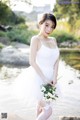 A woman in a white dress holding a bouquet of flowers.