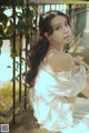 A woman in a white dress sitting on a railing.