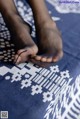 A woman's feet in black stockings on a blue and white blanket.