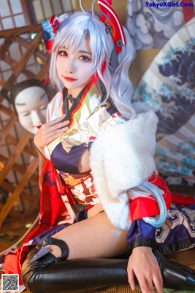 A woman in a kimono sitting on the floor with a fan.
